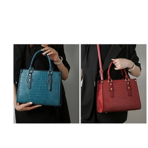 Close-up of crocodile pattern tote bags in dark teal and burgundy with gold hardware