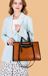 Vue détaillée du sac cabas marron à motif crocodile avec poignées noires et ferrures dorées