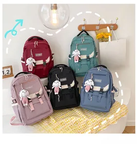 Selection of five nylon student backpacks in multiple colors with plush bunny charms