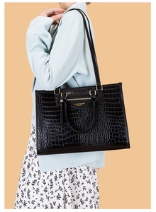 Détail du sac cabas noir à motif crocodile avec garnitures dorées élégantes