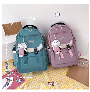 Detail of minimalist school backpacks with bunny pendants and adjustable buckles