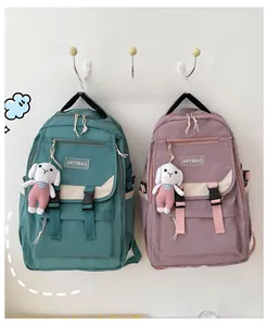 Detail of mint green and purple nylon backpacks with cute bunny plush keychains