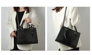 Detail view of black crocodile pattern tote bag with gold hardware worn by a model