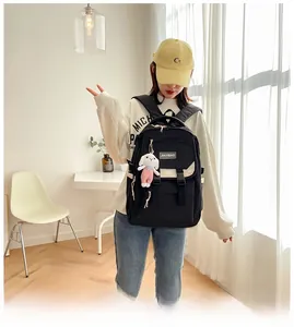 Detail of black nylon backpack featuring white contrast buckles and a cute plush rabbit charm
