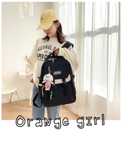 Detail of black nylon school backpack with contrast design and pink rabbit plush charm