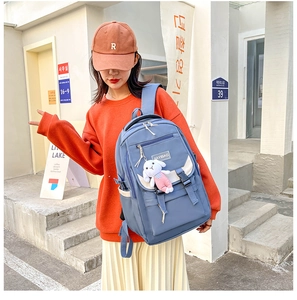 Close-up of blue large-capacity backpack with Jiayibag logo and pink rabbit charm accessory