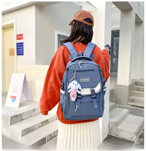 Detail of dark blue school backpack featuring buckle straps and cute bunny plush charm