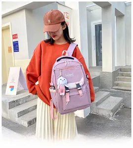 Close-up of a purple nylon school backpack with multiple pockets and a cute bunny charm