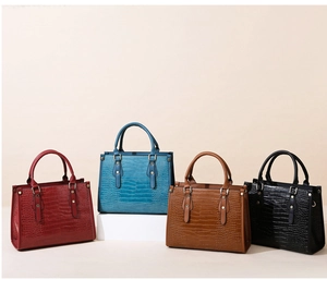 Close-up of four embossed crocodile leather handbags in red, blue, brown, and black