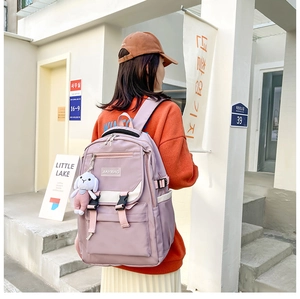 Detail of light purple school backpack with white bunny plush charm and buckle