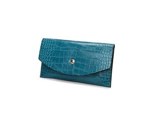 Detail of teal crocodile embossed faux leather wallet with golden round snap closure