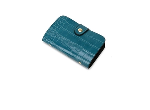 Close-up of crocodile texture card wallet in teal with a round golden snap button