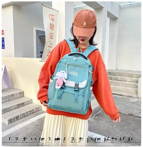 Detail of teal blue nylon backpack showing durable fabric and cute white rabbit keychain