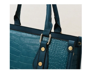 Detailed close-up of teal crocodile embossed texture and golden metal handle hardware