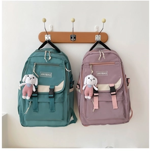 Detail of durable backpack showing flap buckle design and white rabbit plush pendant