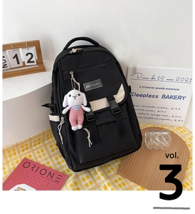 Close-up of black and white contrast backpack featuring side buckles and cute rabbit pendant