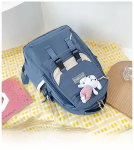 Detail view of a blue nylon backpack with buckle closure and a cute white bunny keychain