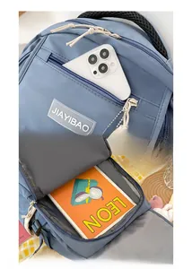 Macro detail of fog blue nylon backpack showing front zip pocket and spacious main compartment