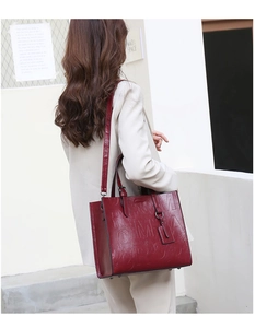 Detail of burgundy tote bag with ROMA embossed texture and adjustable shoulder strap