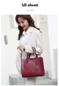 Macro detail of wine red tote bag with embossed letters on premium faux leather