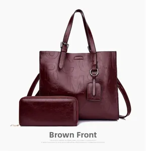 Detail view of burgundy tote bag and matching wallet with embossed letter pattern