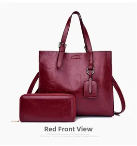 Detail view of burgundy tote and wallet set with embossed letters and silver hardware