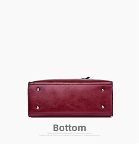 Detail view of deep red embossed leather handbag base with four silver metal feet