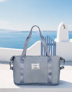 Close-up of a blue-grey waterproof travel bag with reinforced handles and brand logo