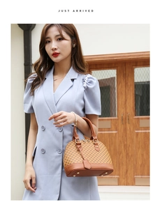 Classic brown monogram shell bag carried by a model in a light blue dress for a chic look