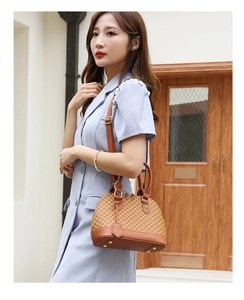Close-up of brown shell bag with geometric clover pattern and adjustable leather strap