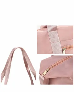 Close-up of reinforced stitching, durable metal zippers, and pink nylon travel bag details