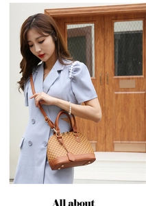 Brown monogram shell handbag with leather handle and protective metal feet studs