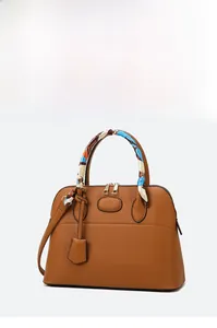 Detail of brown litchi pattern leather satchel with silk scarf wrapped handles and dual zippers