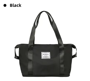 Detail of waterproof black travel bag showing reinforced handles and fashion woven label