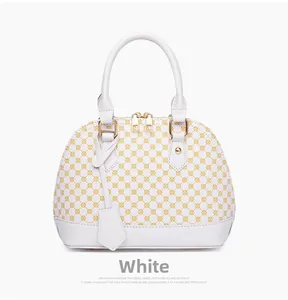 Detail of white shell handbag with yellow geometric patterns and gold hardware