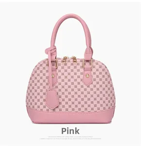 Detailed view of pink shell bag with geometric dot pattern and golden metal zippers