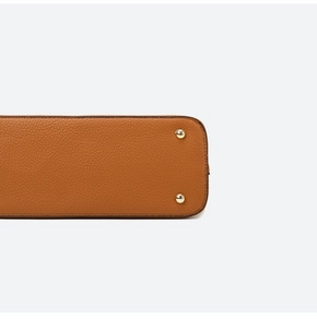 Detail of brown lychee grain leather handbag base with gold protective metal feet