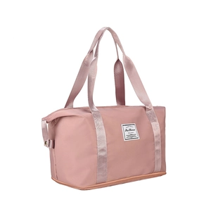 Detail view of pink waterproof nylon travel bag with reinforced straps and logo label