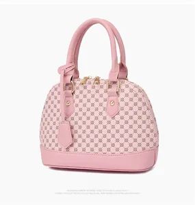 Detail of pink shell handbag with monogram pattern and gold zipper hardware