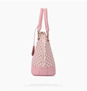 Detailed side view of pink shell handbag featuring geometric circular print and gold hardware
