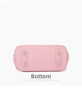 Close-up of pink leather handbag bottom with four protective gold metal feet and stitching