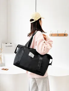 Close-up of black waterproof nylon travel bag featuring large capacity and fashion label
