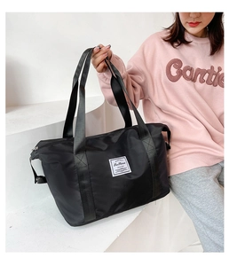 Detail of black nylon travel bag with wide straps and Fashion patch on geometric background