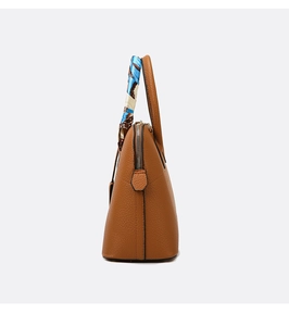Close-up of brown litchi pattern handbag with a decorative silk scarf on the handle