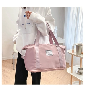 Lifestyle view of large dusty pink travel bag with shoulder straps and front patch