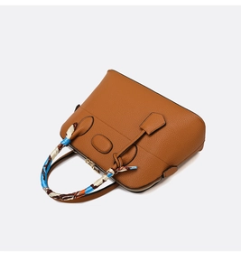Detailed view of caramel brown pebble leather tote bag with elegant silk scarf wrap handle
