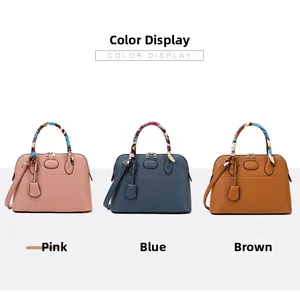Three shell-shaped handbags in pink, blue, and brown with decorative handle scarves
