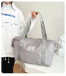 Gray waterproof nylon travel tote bag with wide straps and minimalist fabric label detail