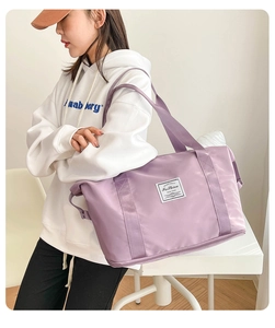 Close-up of lavender nylon travel bag with expanded zipper bottom and fashion label detail
