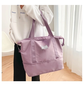 Close-up of a purple high-capacity gym bag featuring wide straps and fashion label